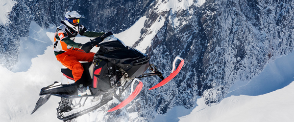 snowmobile rider jumping in the snow
